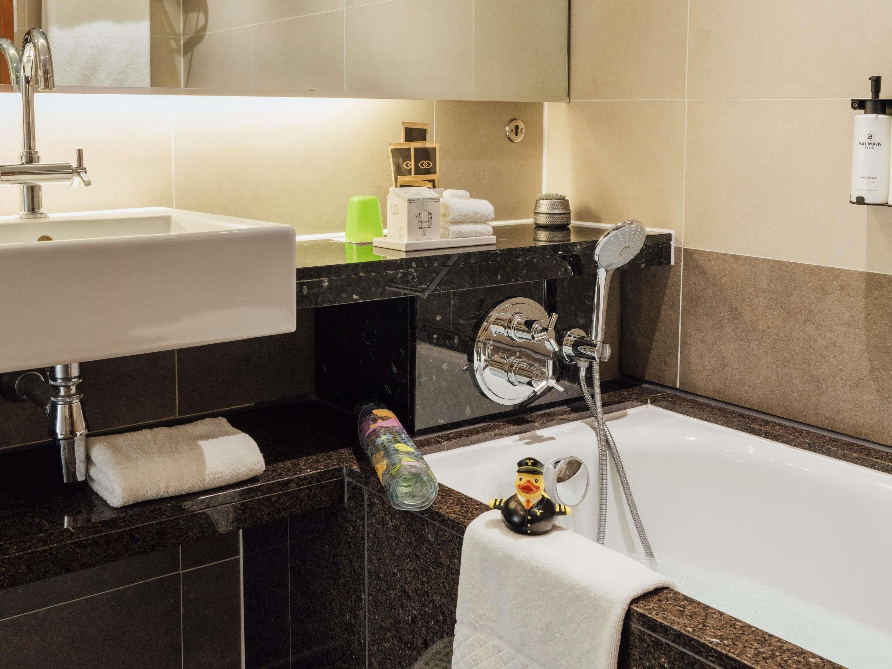 A modern bathroom with a sink, mirror, and shower.
