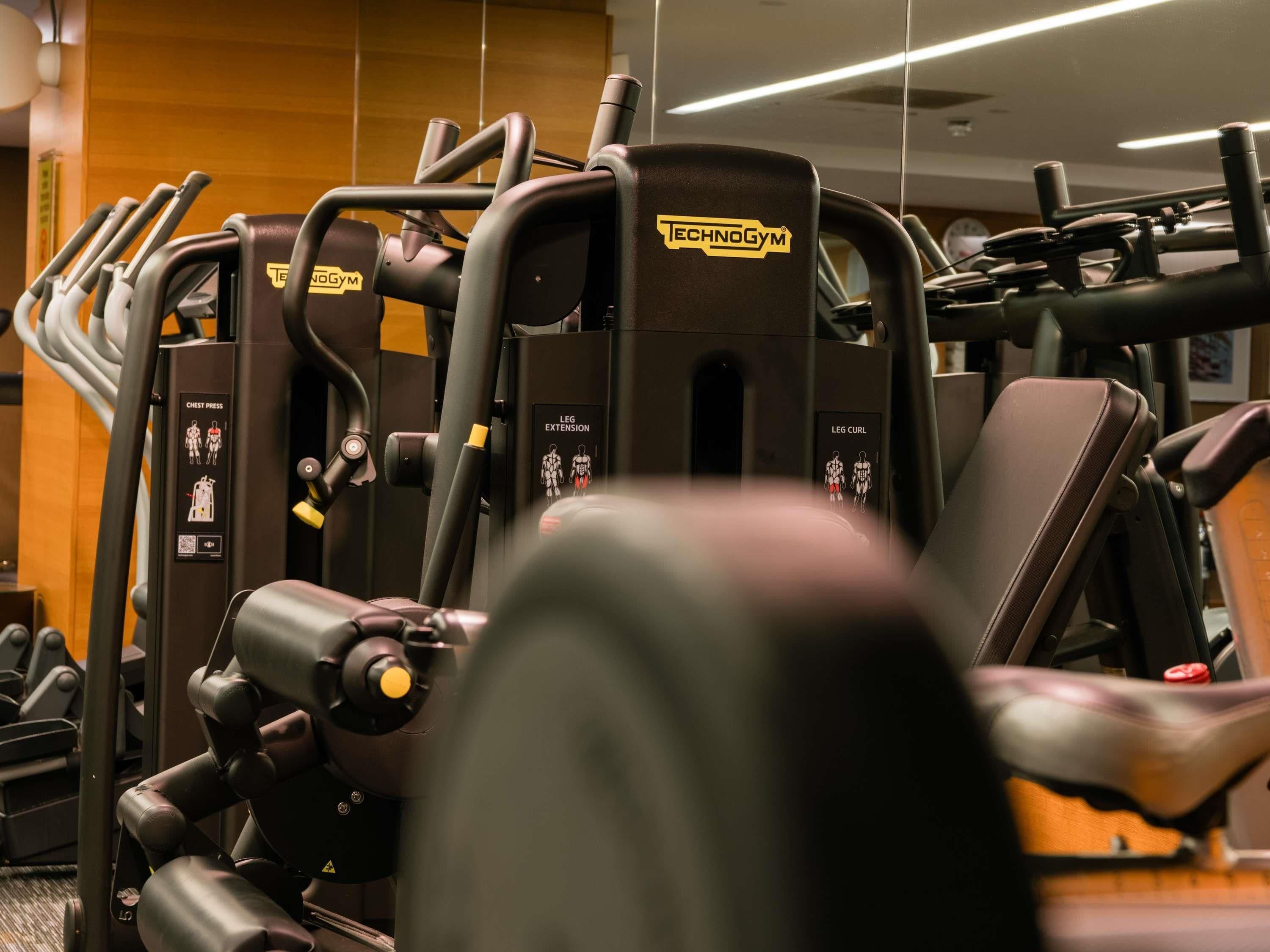 A gym with various exercise machines, including a chest press and leg extension machine.