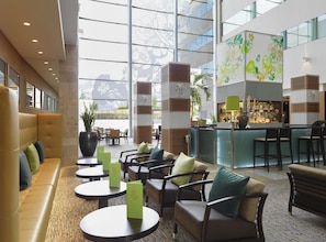 A spacious lobby with a seating area, a reception desk, and a bar.