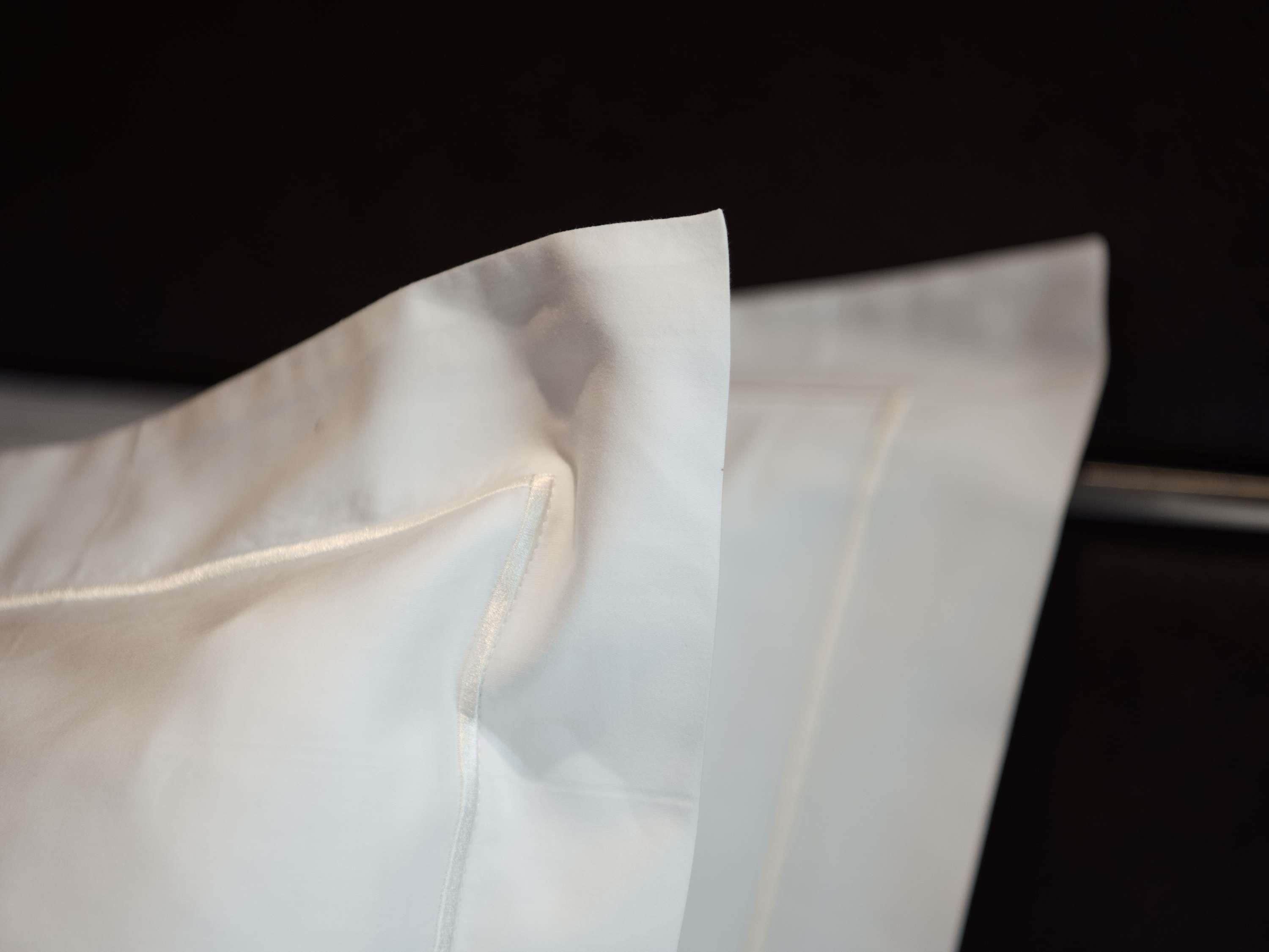 A white fabric with a visible seam and a folded edge.