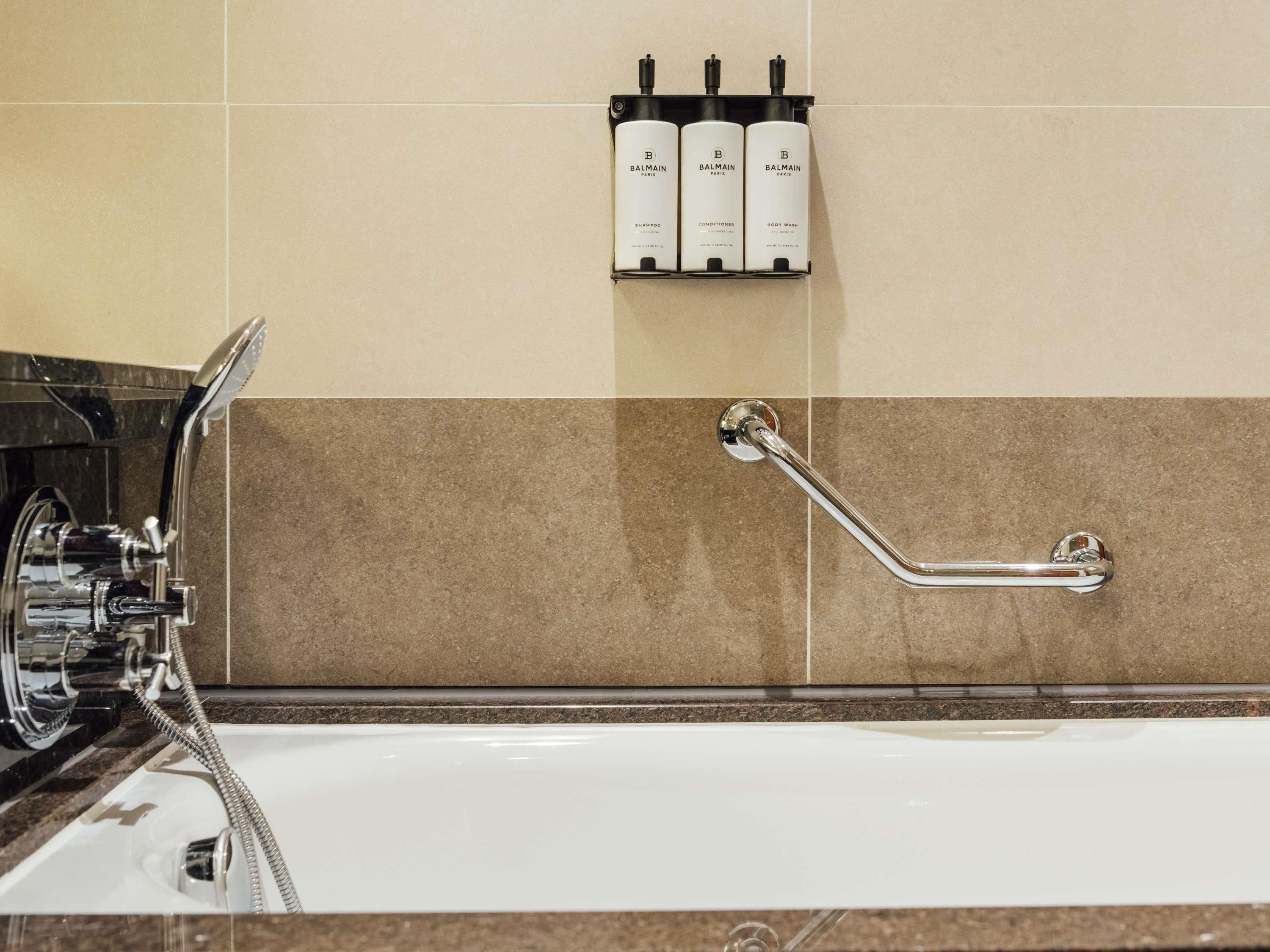 Ein Badezimmer mit einer Badewanne, einer Dusche und einer Haltestange.