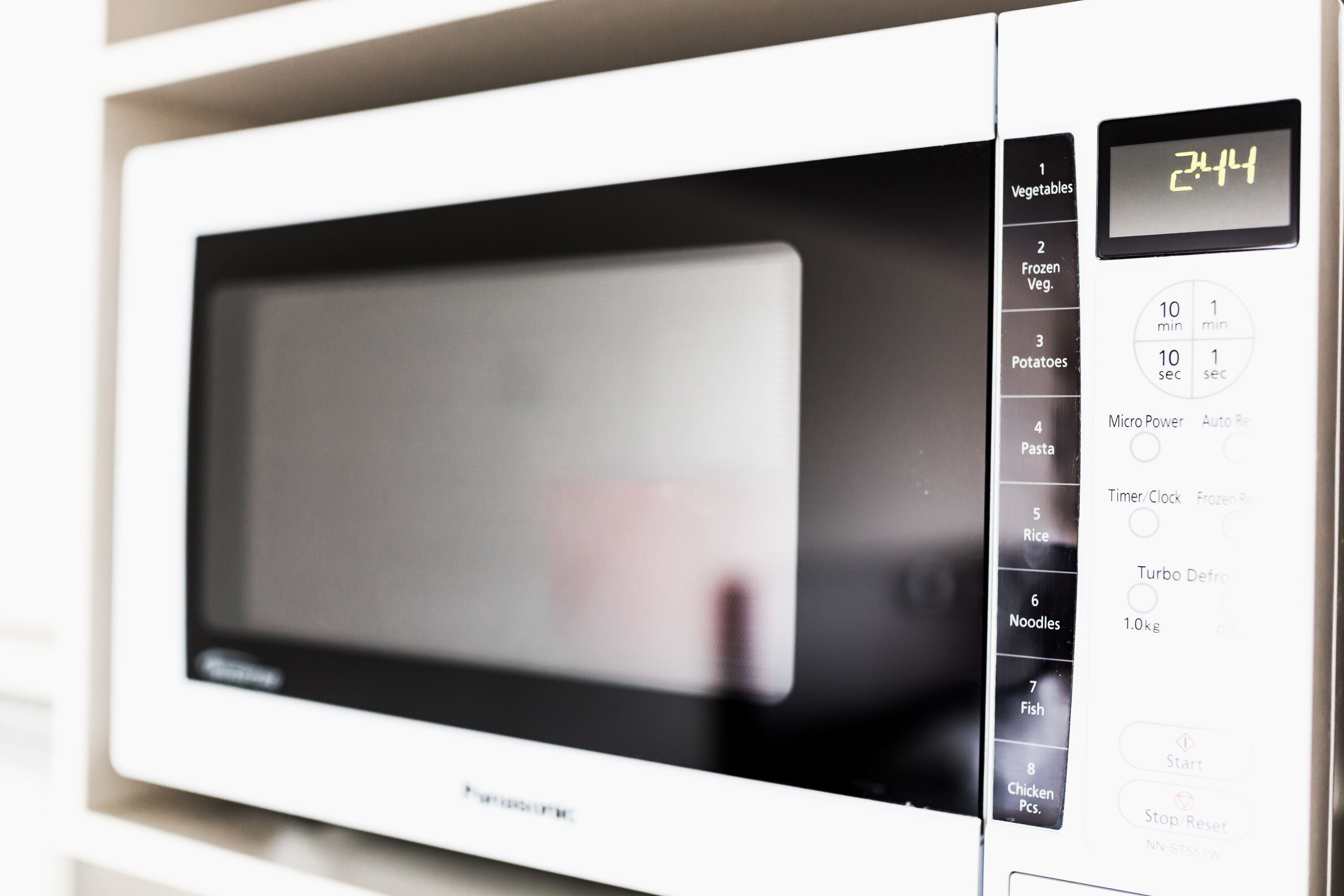 A white microwave with a digital display showing 2444.