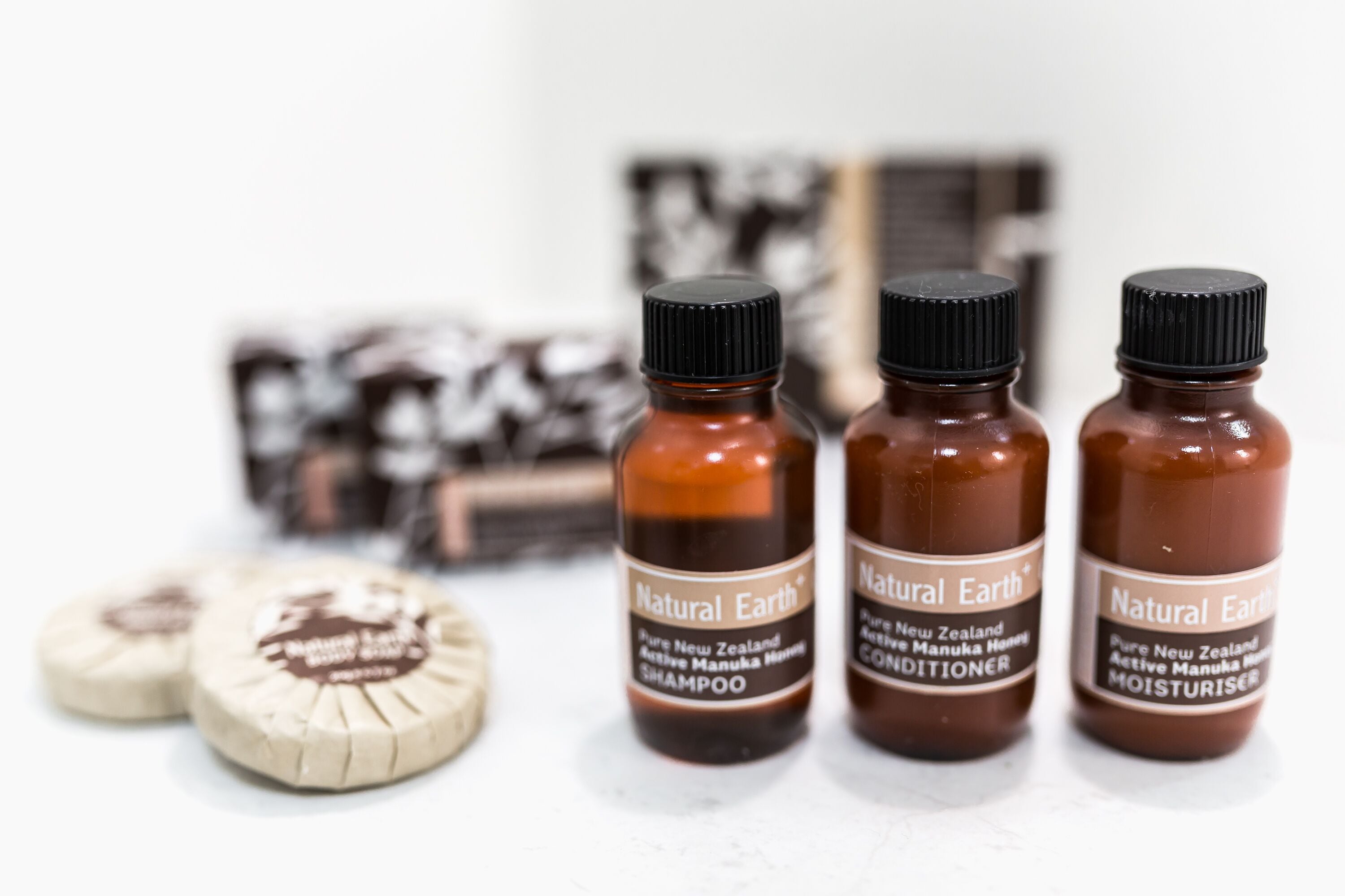Three bottles of Natural Earth products: shampoo, conditioner, and moisturizer.