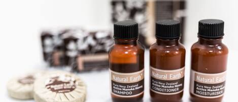 Three bottles of Natural Earth products: shampoo, conditioner, and moisturizer.