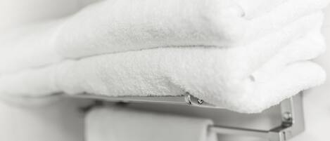 A white towel folded neatly on a metal towel rack.