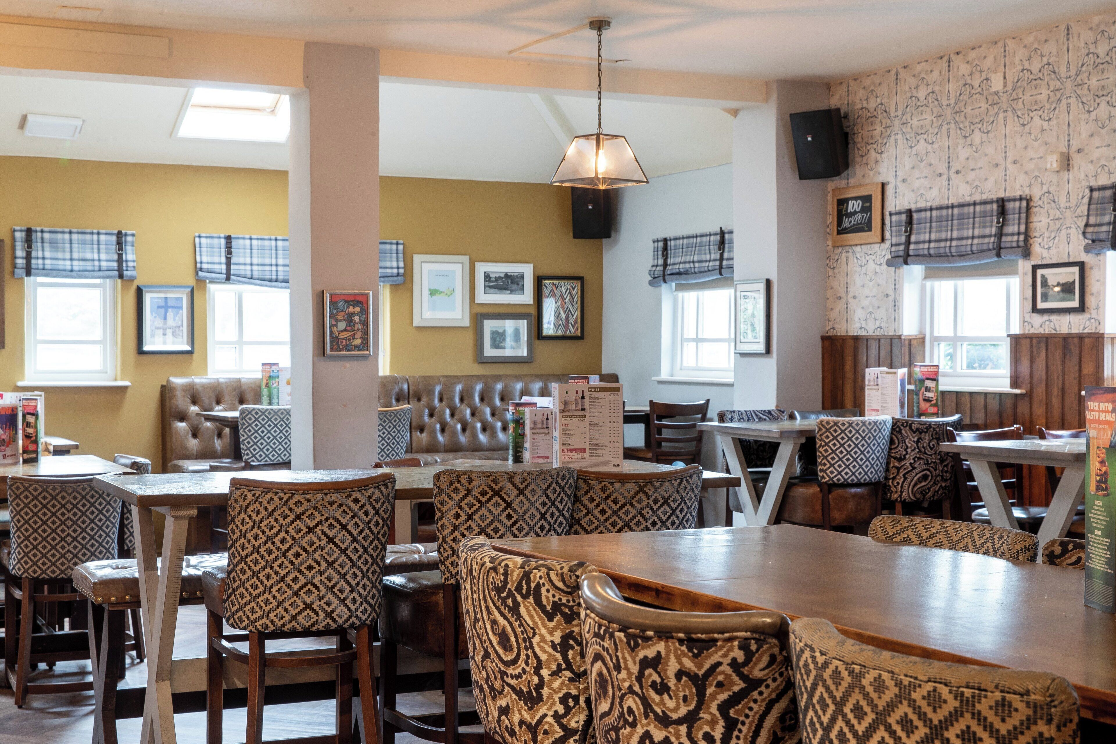 A restaurant with a central seating area, a bar, and a booth.