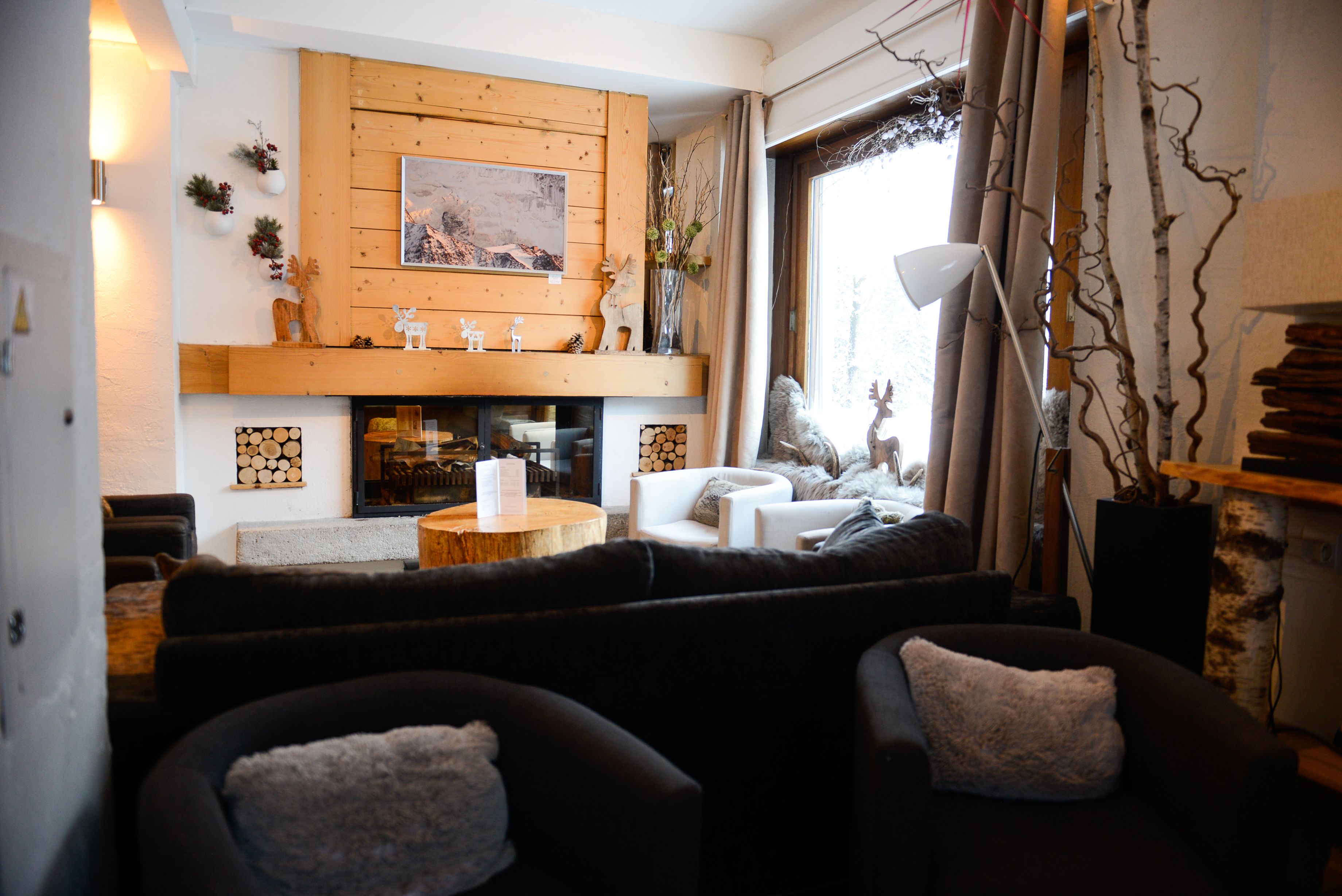 Una sala de estar acogedora con chimenea, asientos cómodos y vistas al exterior.
