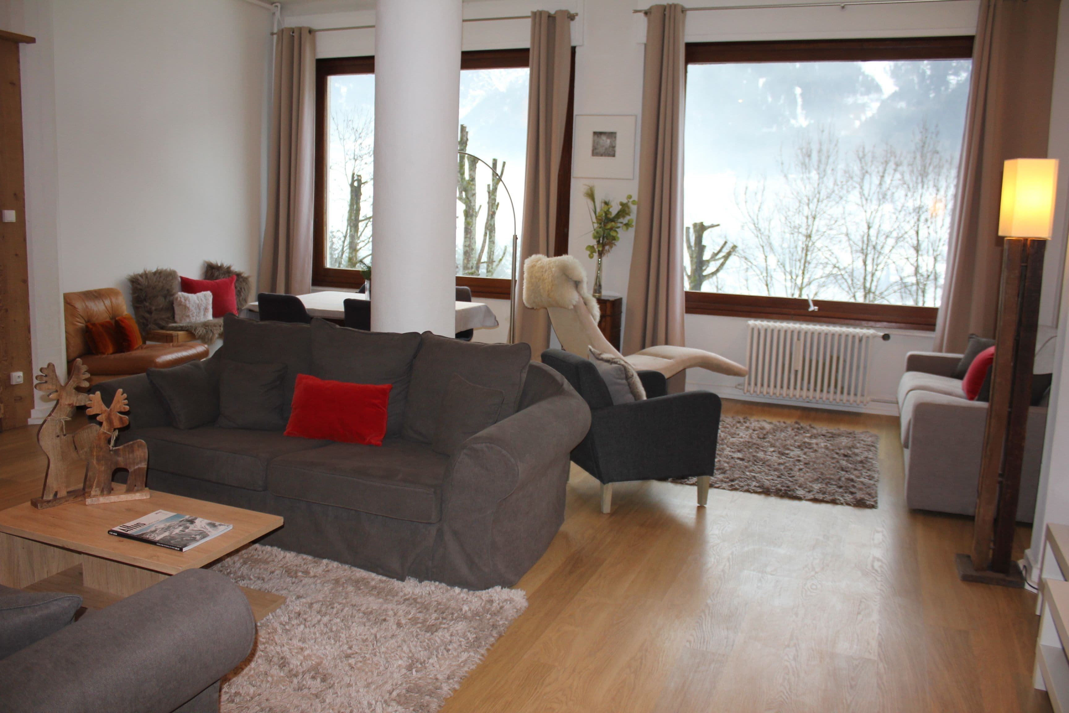 Una sala de estar moderna con un sofá gris, una mesa de centro y una chimenea.
