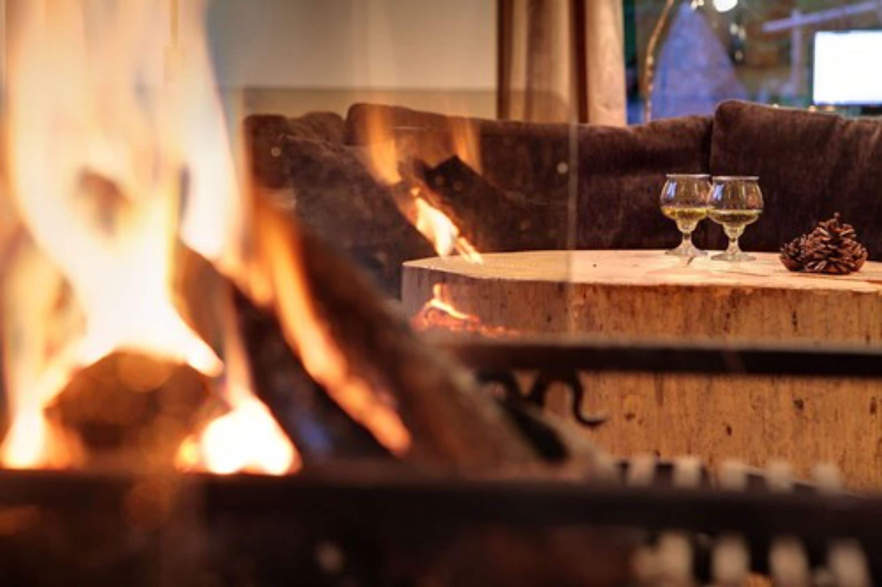 Une pièce chaleureuse avec une cheminée, une table en bois et un canapé marron.