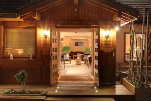 Entrada de una cabaña de madera con un interior acogedor, chimenea y comedor.