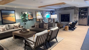 A spacious living room with a large sofa, a coffee table, and a fireplace.