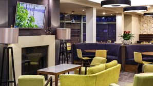 A modern lounge area with a fireplace, seating, and a television.