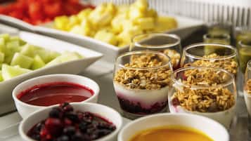 A variety of food items including fruits, granola, and desserts in bowls and glasses.