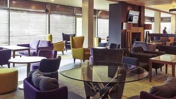 Ein stilvoller Lounge-Bereich mit runden Tischen und bequemen Sitzgelegenheiten.