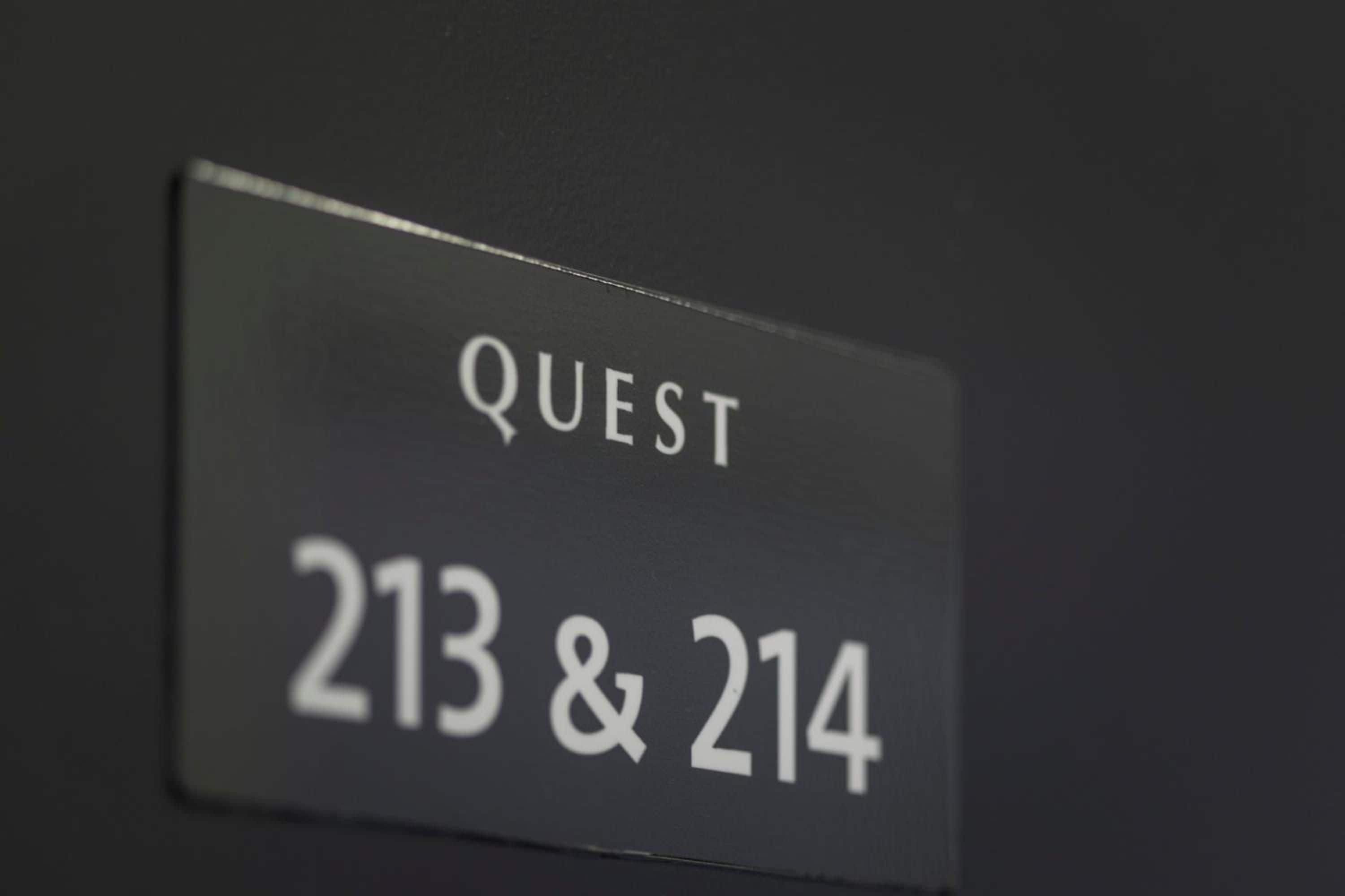A sign with the text 'QUEST 213 & 214' indicating room numbers.