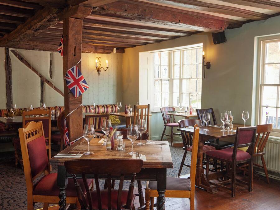 Une auberge traditionnelle avec des meubles en bois, un drapeau et une ambiance chaleureuse.