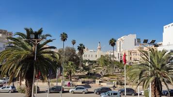 A parking area with multiple cars and palm trees.