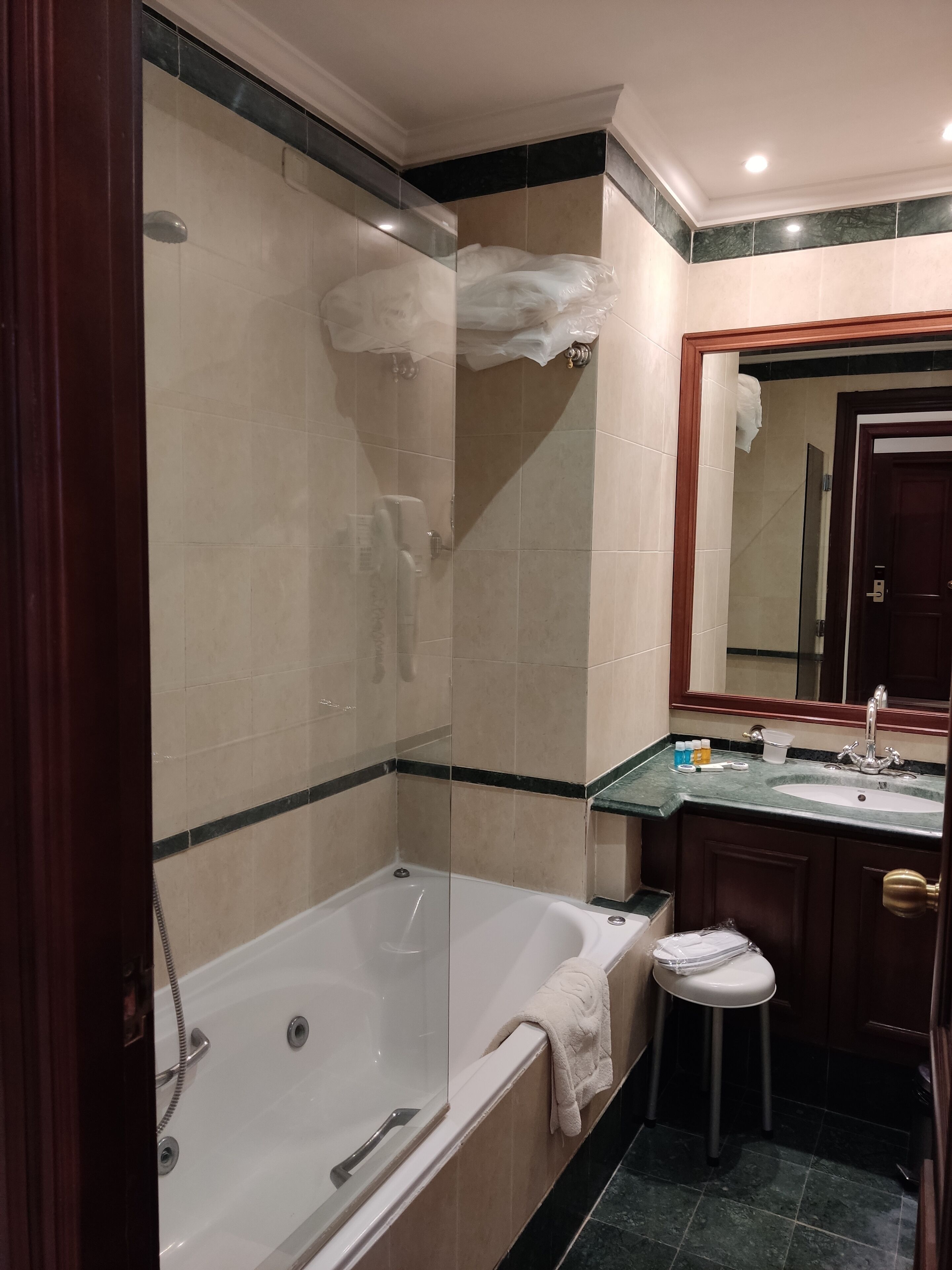 A modern bathroom with a glass-enclosed shower, a freestanding bathtub, and a vanity with a sink and mirror.