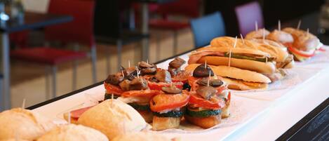 Una mesa de buffet con diversos sándwiches y aperitivos.