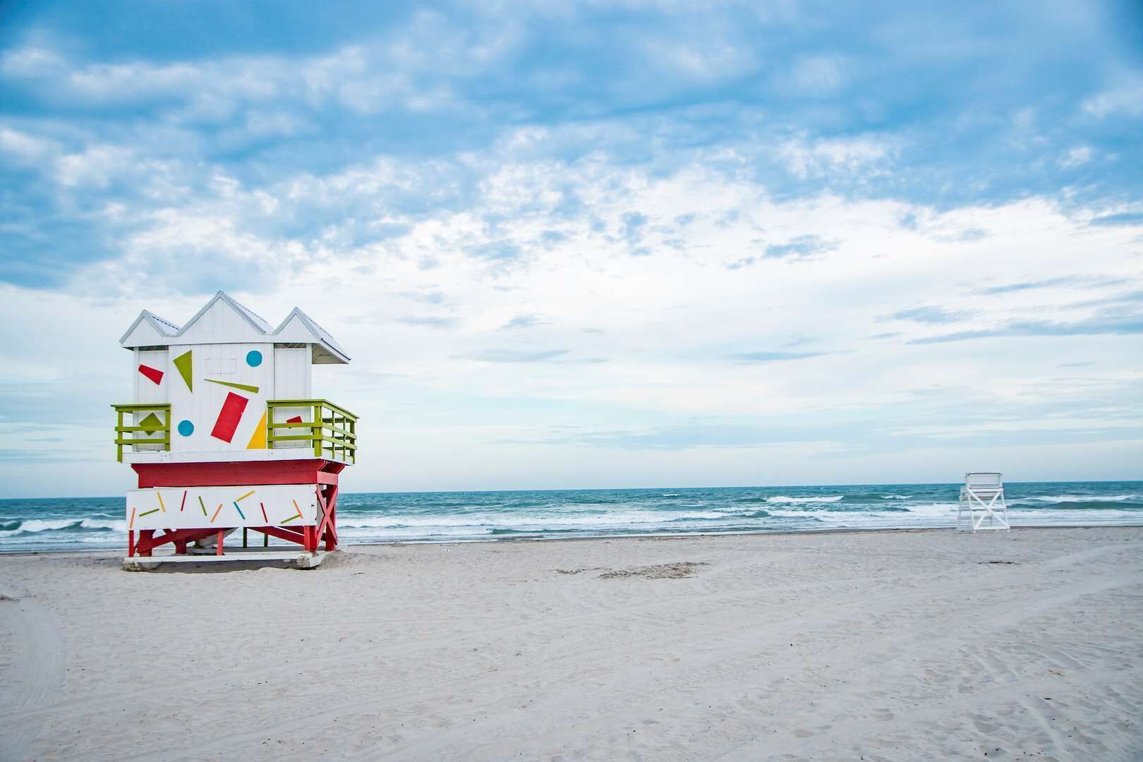 Une tour de surveillance, ornée de motifs géométriques, sur une plage.