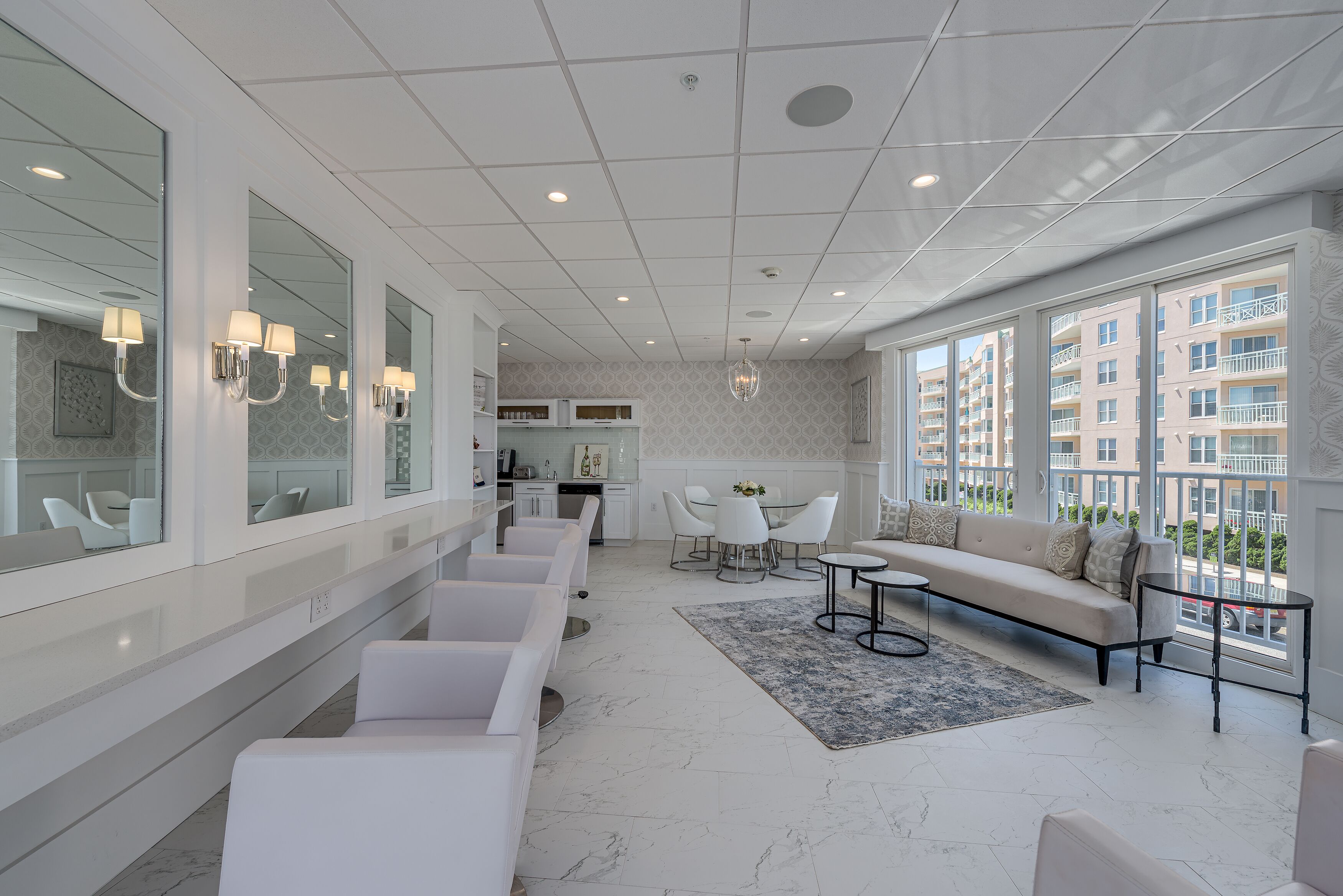 A modern hotel lobby with a seating area, a dining table, and large windows offering a view of the city.