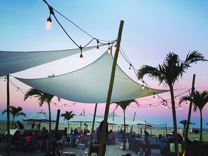 Un restaurante frente al mar con terraza y luces colgantes.