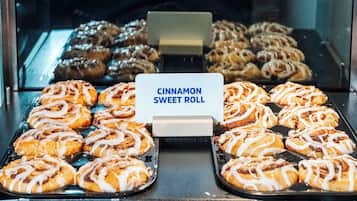 A display case with various baked goods, prominently featuring cinnamon sweet rolls.