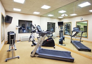 A gym with exercise equipment, a treadmill, and a mirrored wall. - Holiday Inn Express Hotel & Suites Detroit - Utica by IHG (Utica)