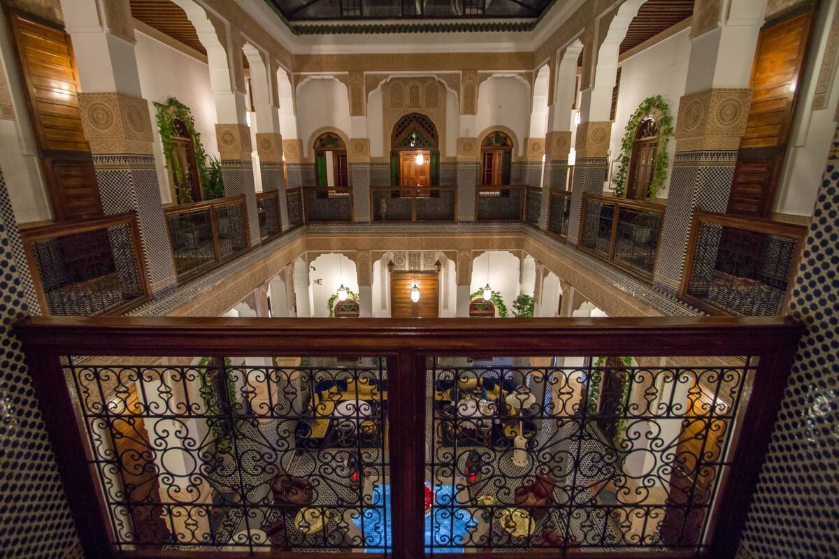 A spacious interior with high ceilings, ornate arches, and a central fountain.