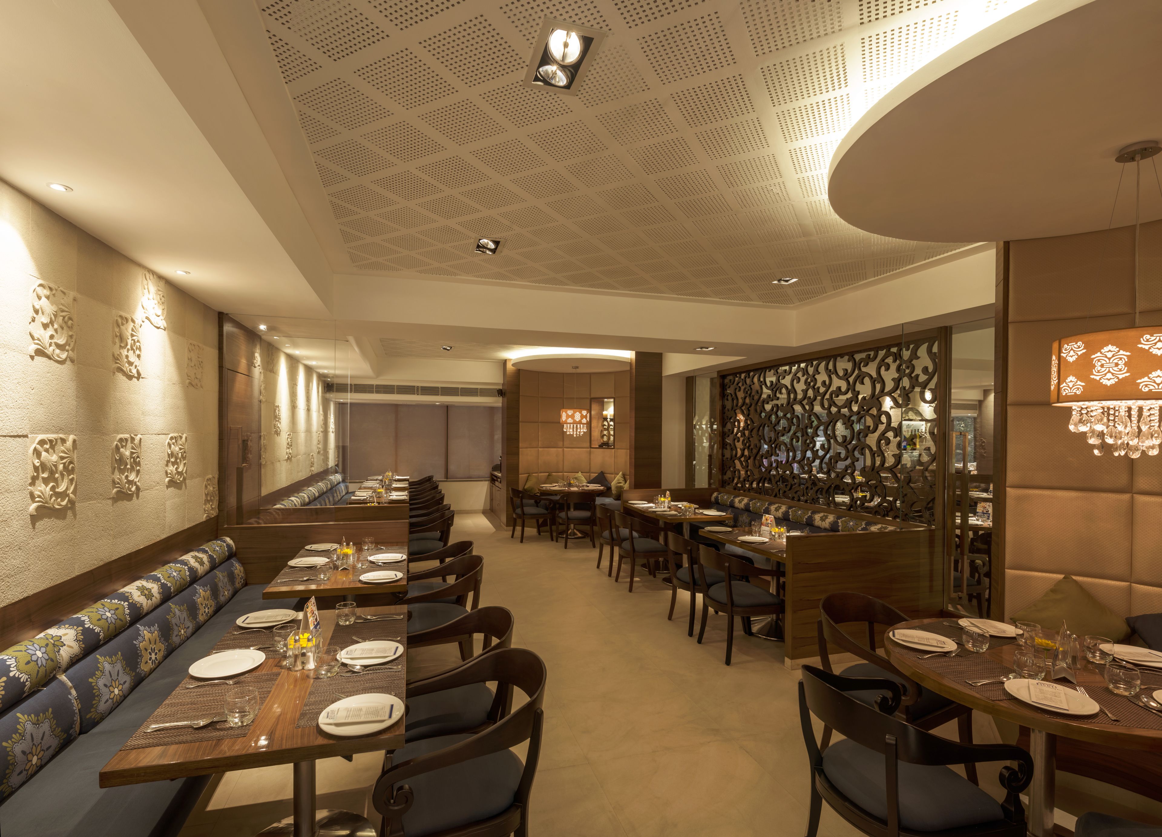 Un restaurant modern amb sostres alts, parets amb dibuixos i una combinació d'assecadors i taules.