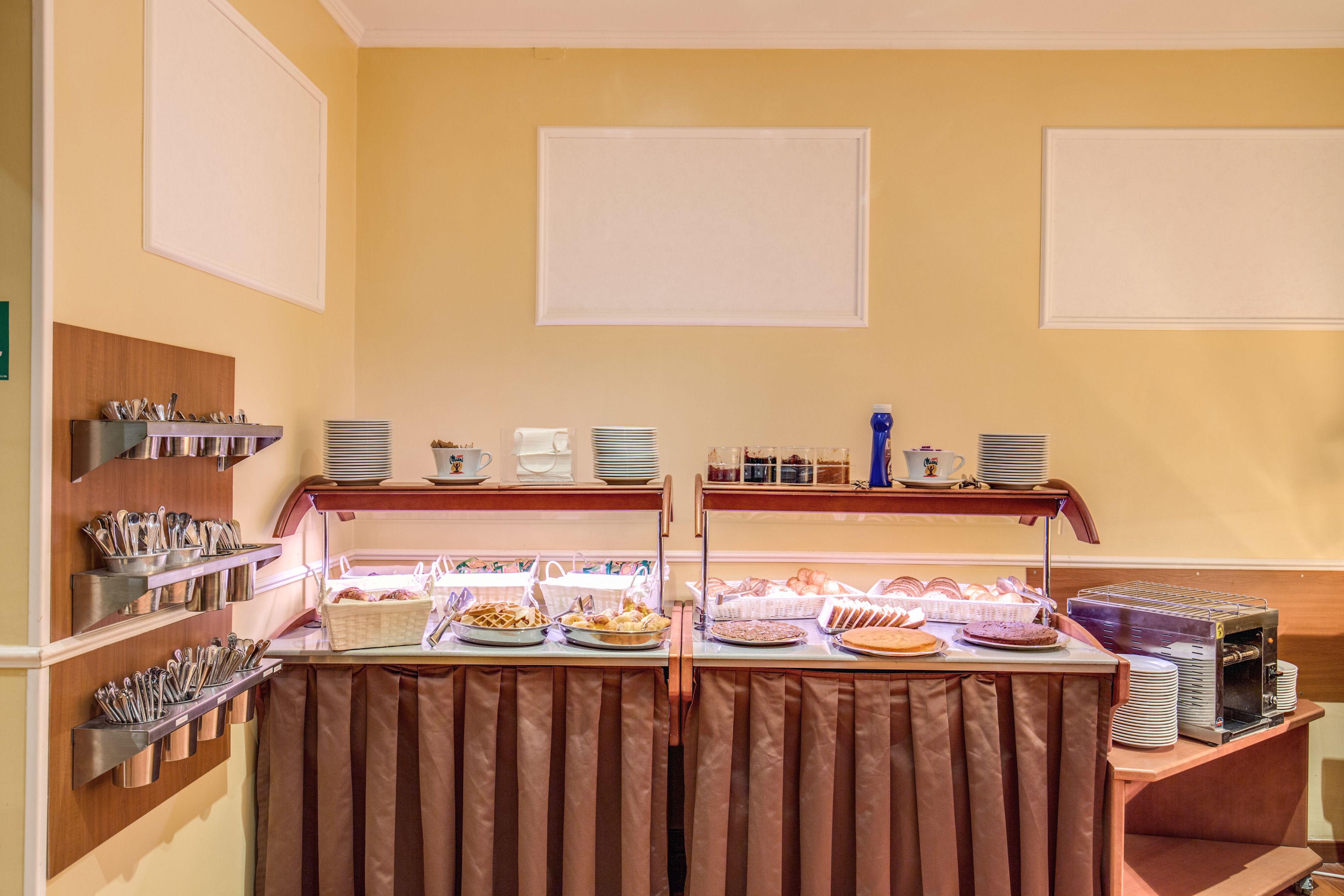 A buffet setup with various food items and utensils.