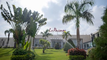 Experience the serene beauty of Le Passage's lush garden, surrounded by tropical plants and palm trees.