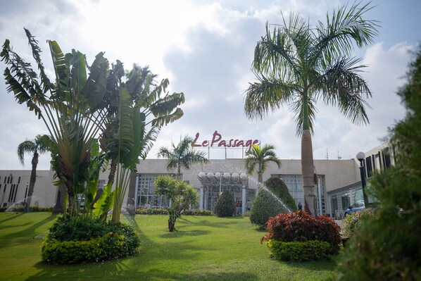 A hotel entrance with palm trees and a well-maintained lawn. - Le Passage Cairo Hotel & Casino (Cairo)