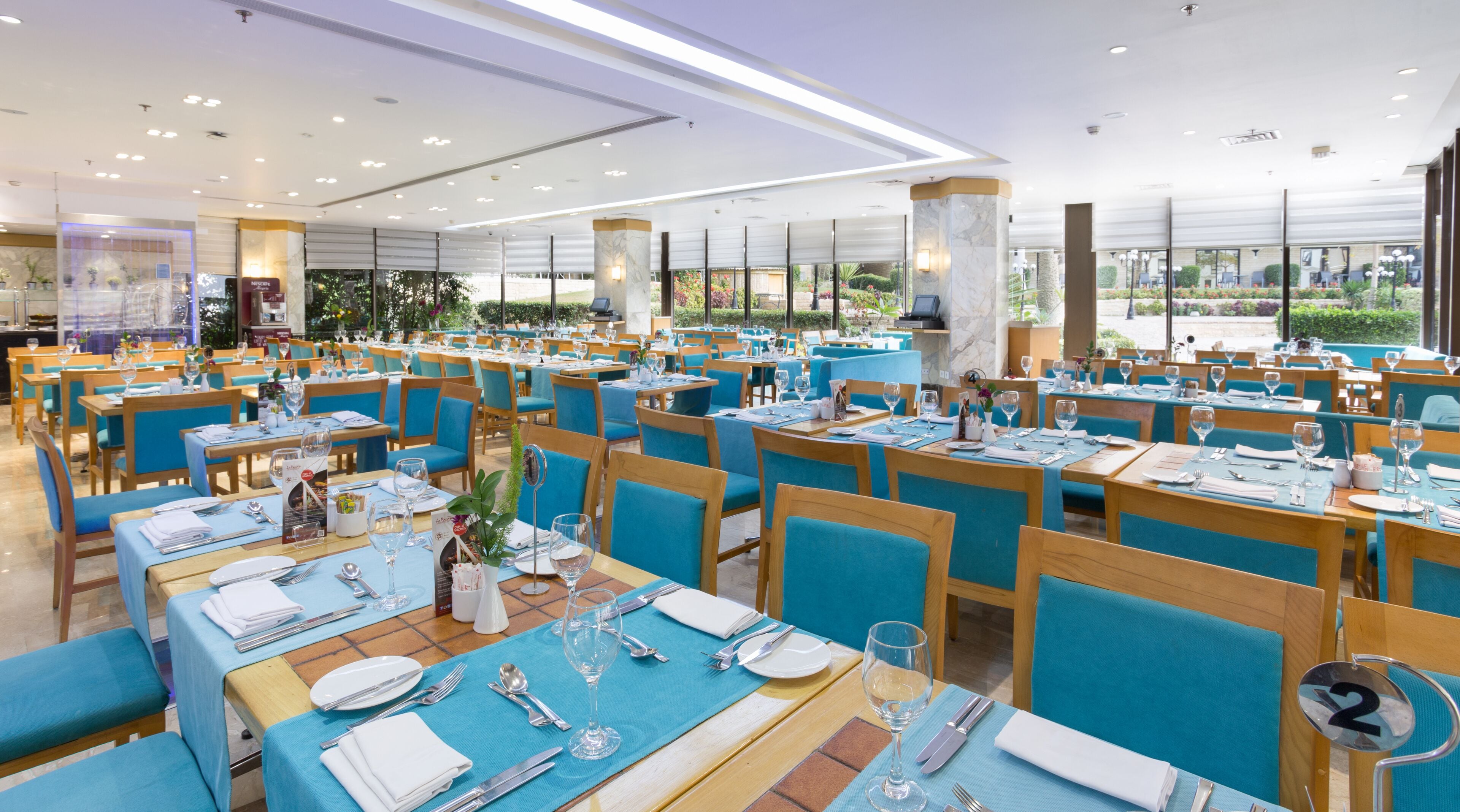 A spacious restaurant with multiple tables and chairs, arranged in a grid pattern.