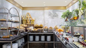 Een buffet met diverse gerechten en een glazen display voor fruit.