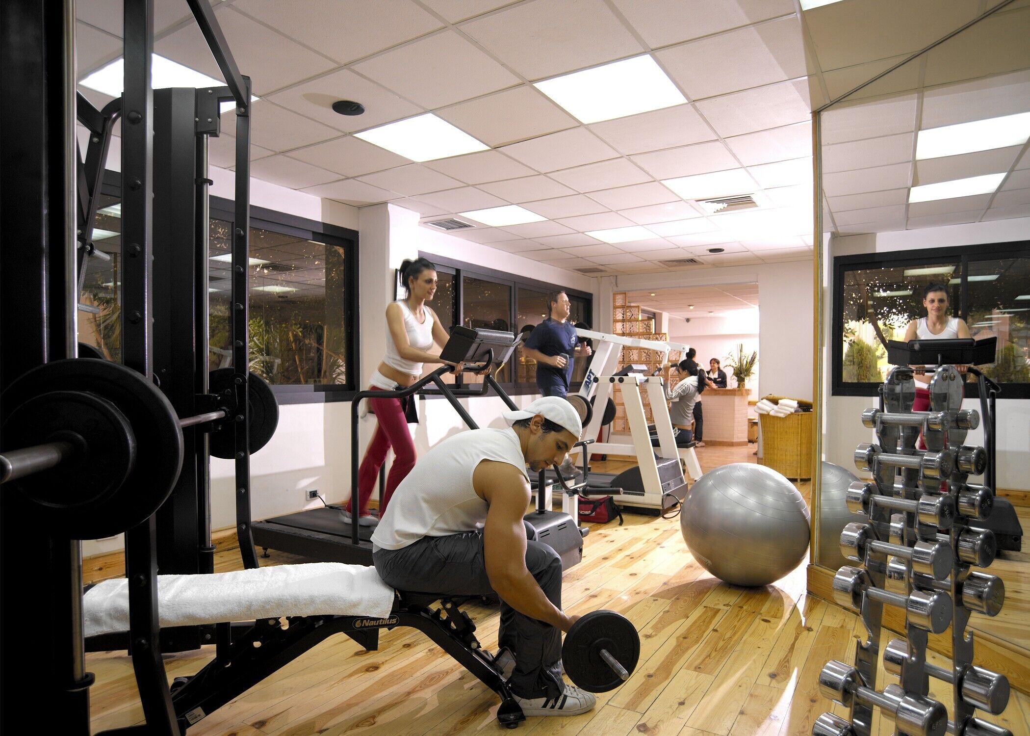 A gym with exercise equipment, a treadmill, and a weight bench.