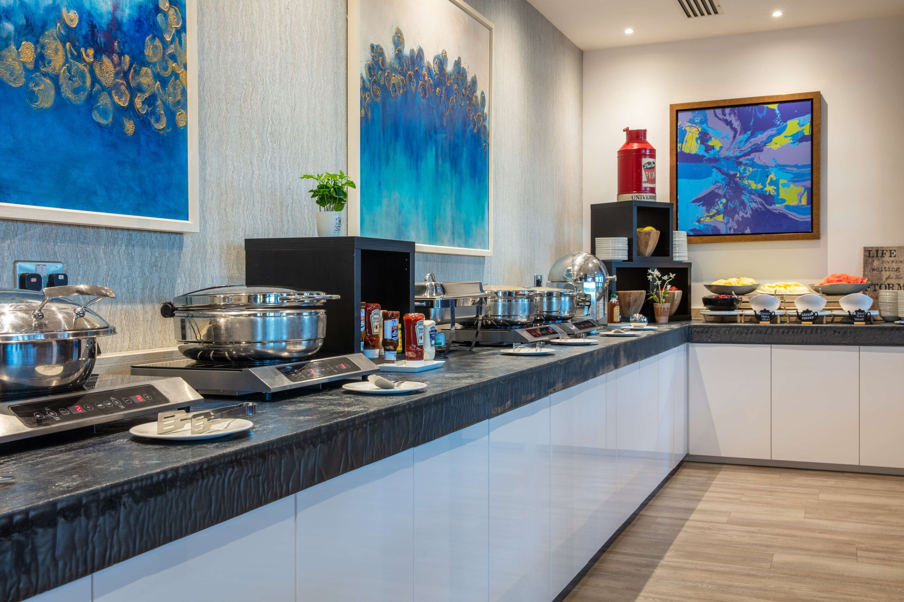 Una cocina moderna con una encimera amplia, electrodomésticos de acero inoxidable y diversos alimentos.