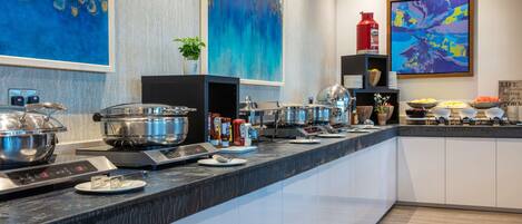 Una cocina moderna con una encimera amplia, electrodomésticos de acero inoxidable y diversos alimentos.