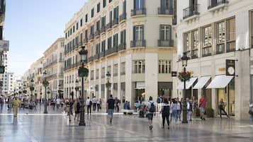 Una animada plaza urbana con edificios históricos, una fuente y zonas de estar al aire libre.