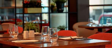 A restaurant table set with glasses, cutlery, and napkins.