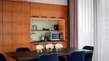 Une cuisine moderne avec des meubles en bois, un four à micro-ondes et une table à manger avec des chaises.