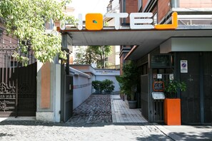 Entrada de un hotel con un cartel que dice 'HOTEL RANGE' y un camino de acceso con portones.