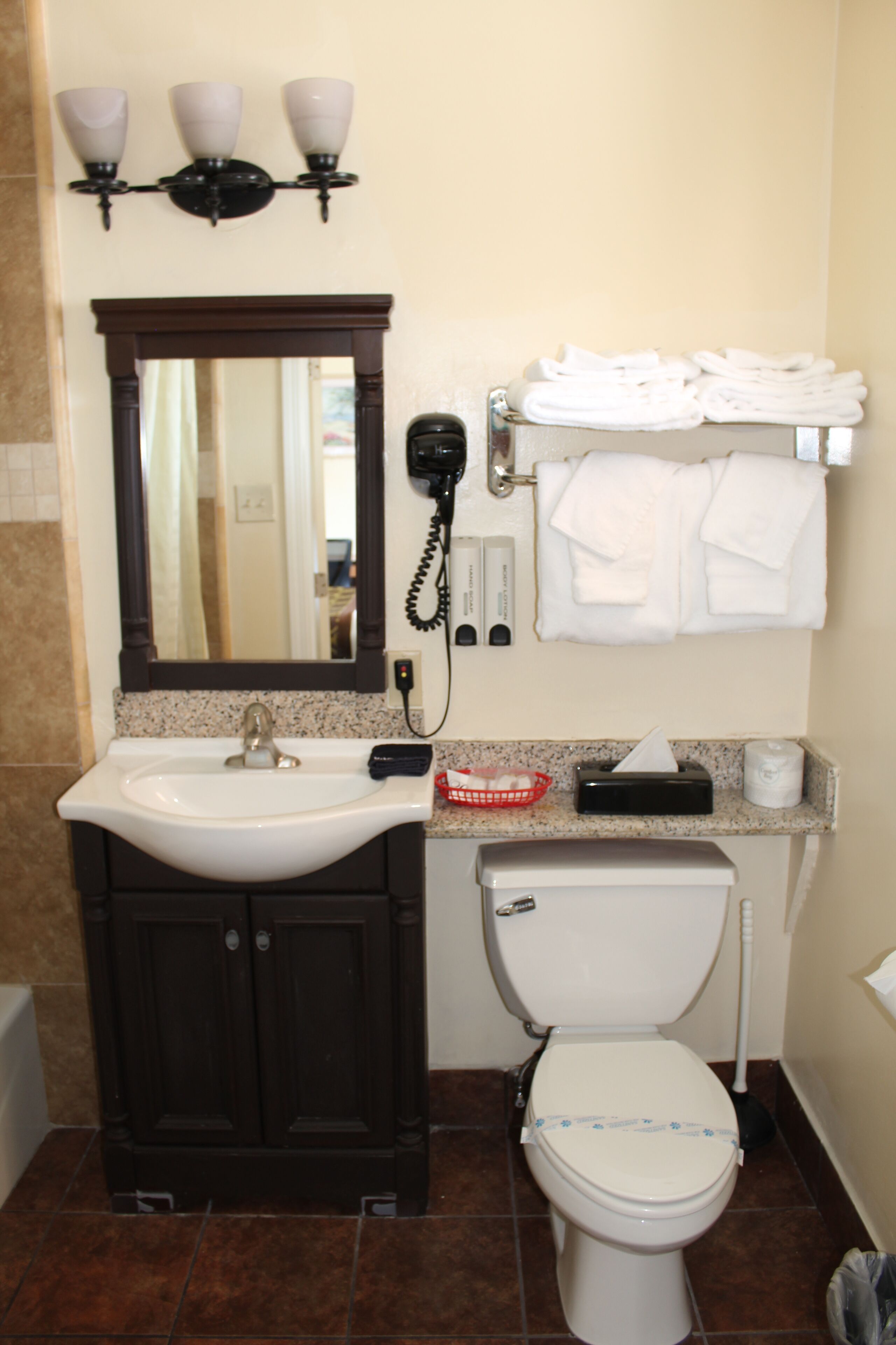 A bathroom with a sink, mirror, towel rack, and toilet.