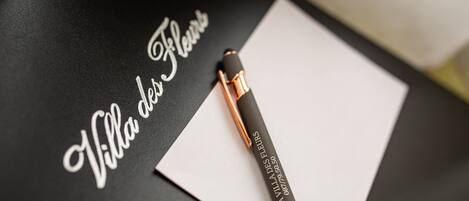 A black surface with a white piece of paper and a pen.
