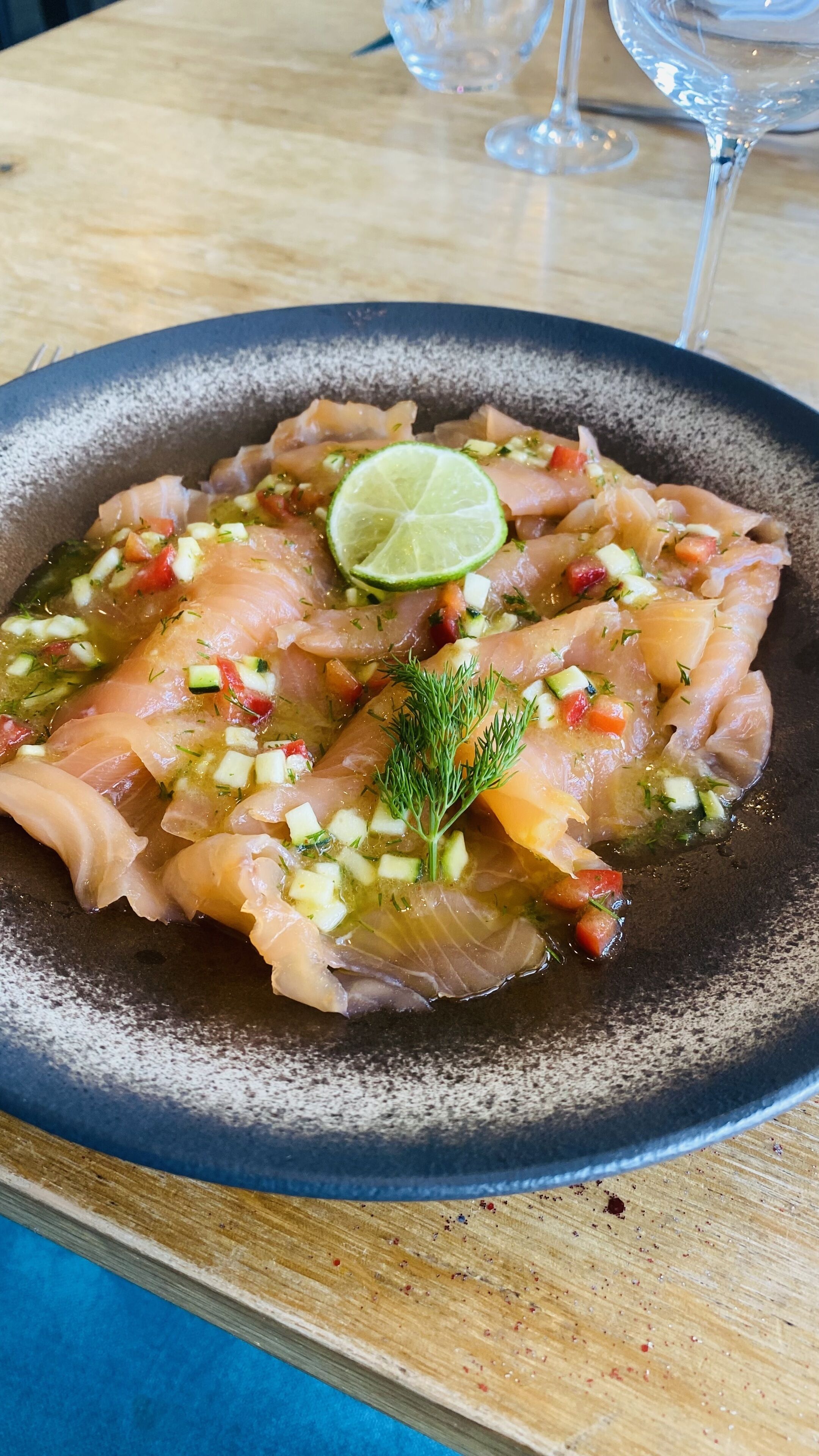 A plate of food with a lime garnish on a dark plate.