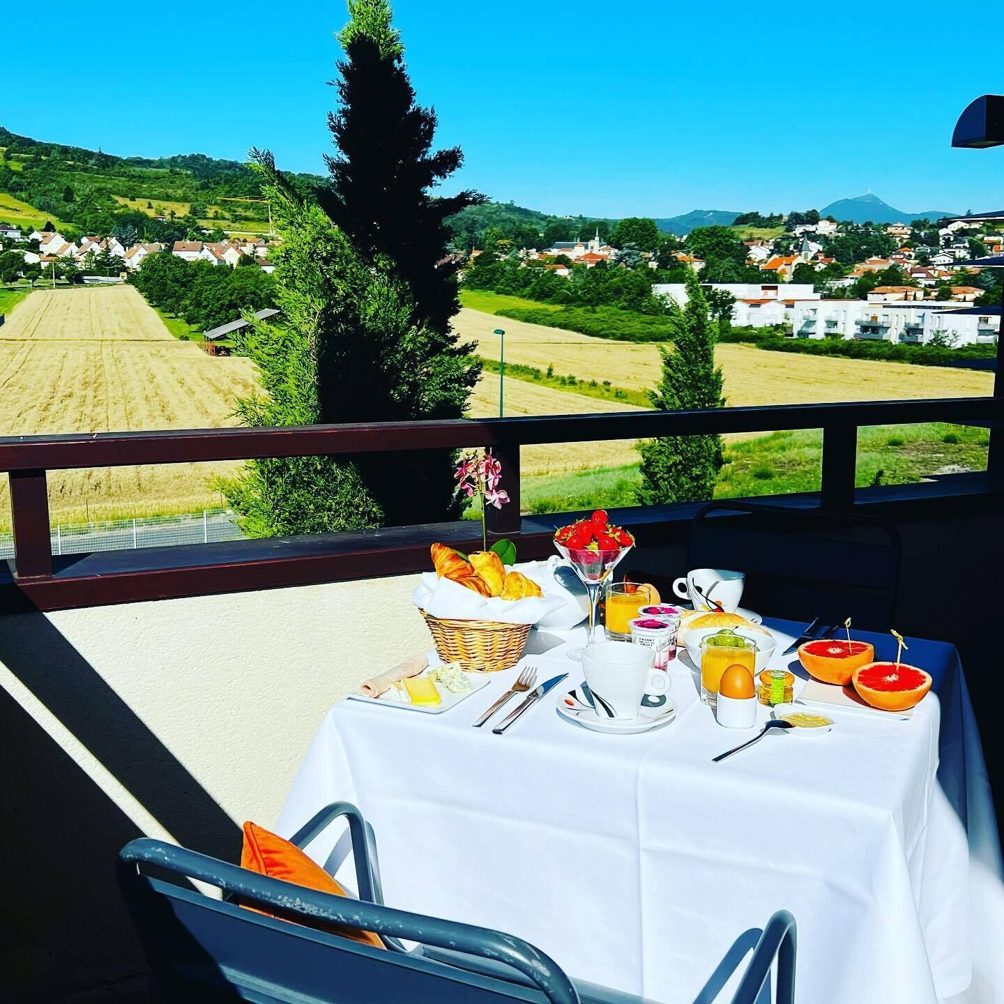 A table set for breakfast with a view of a rural landscape.
