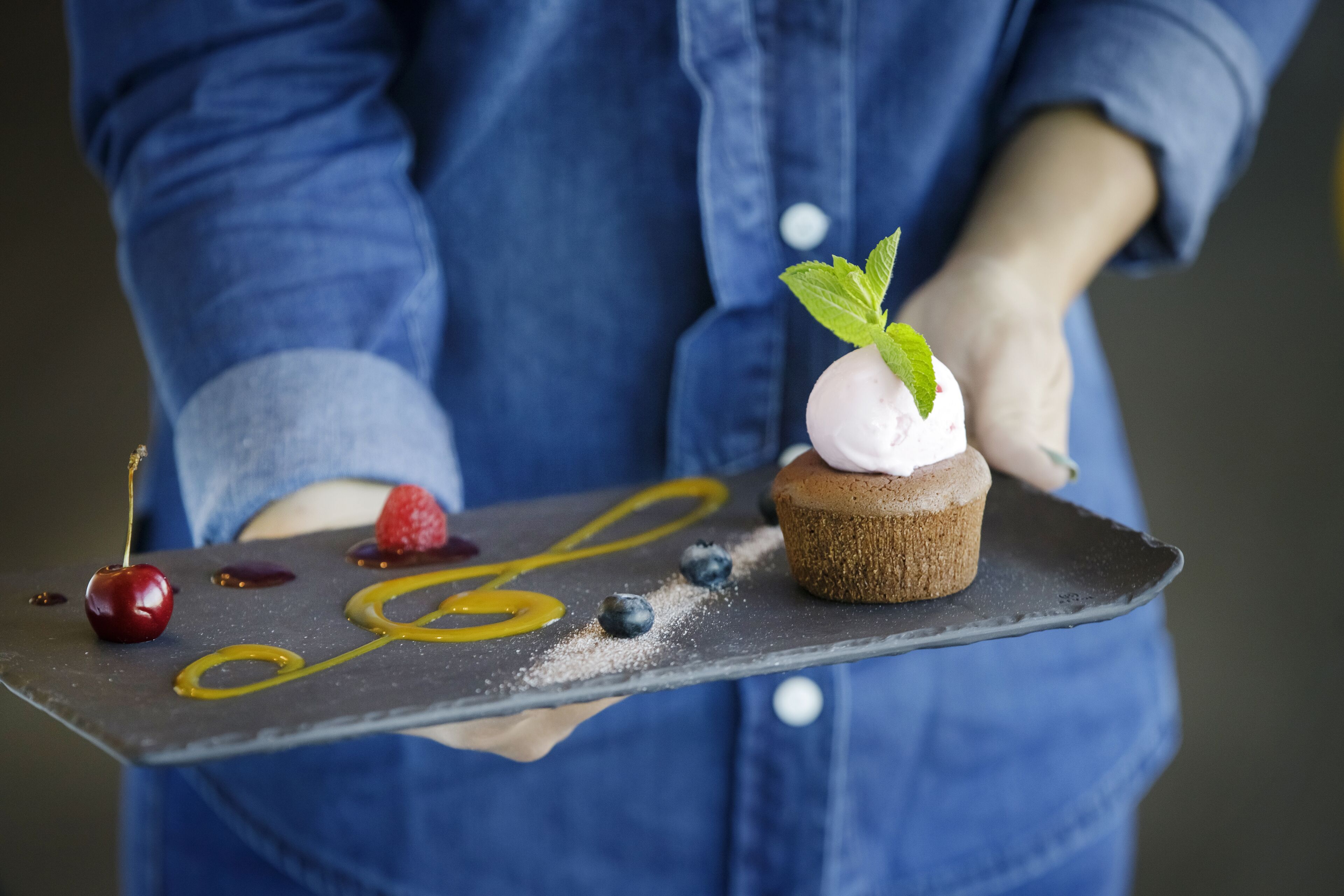 Ein Dessertteller mit Cupcake, Kirschen und Blaubeeren.