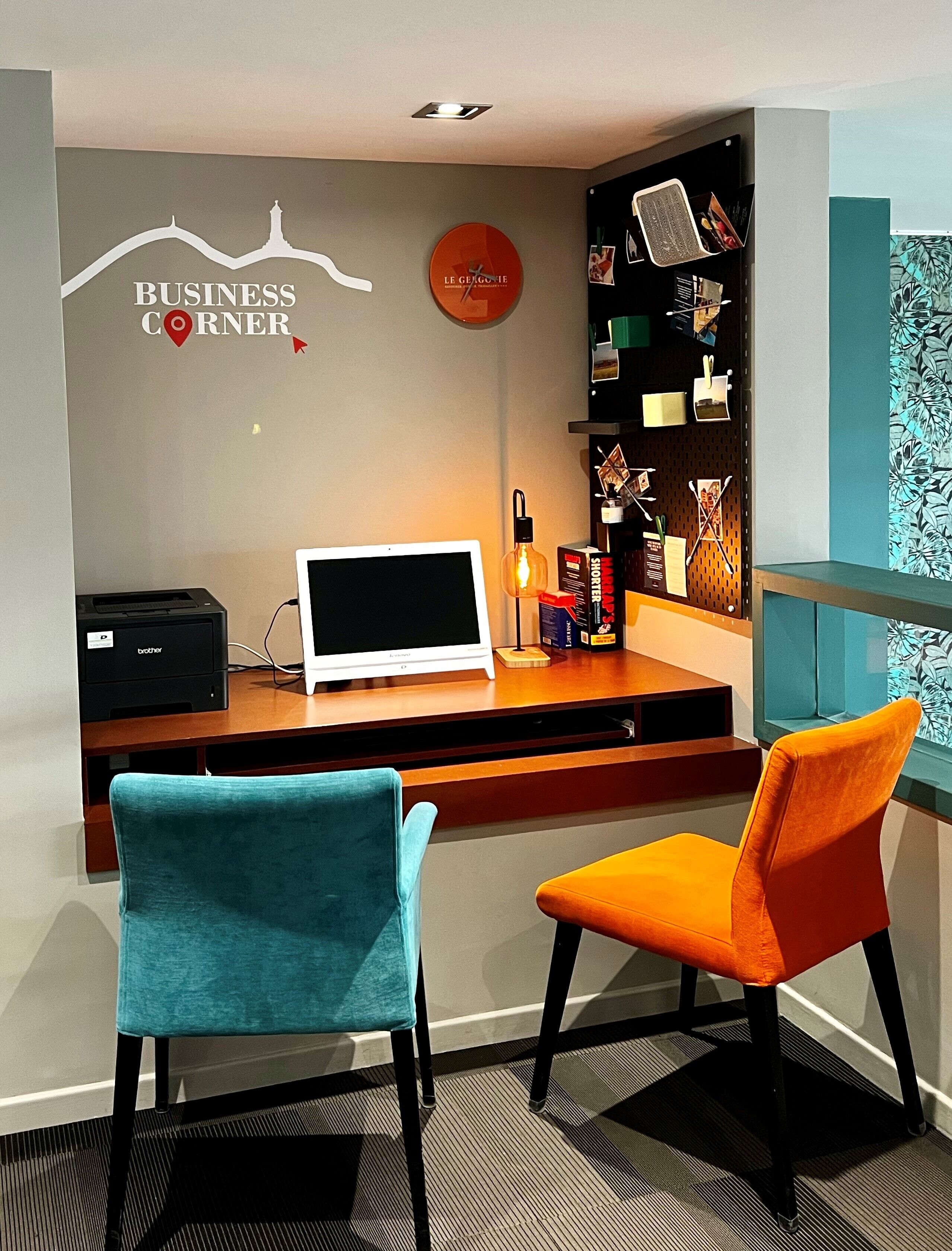 A workspace with a desk, two chairs, a computer, a printer, and a bookshelf.