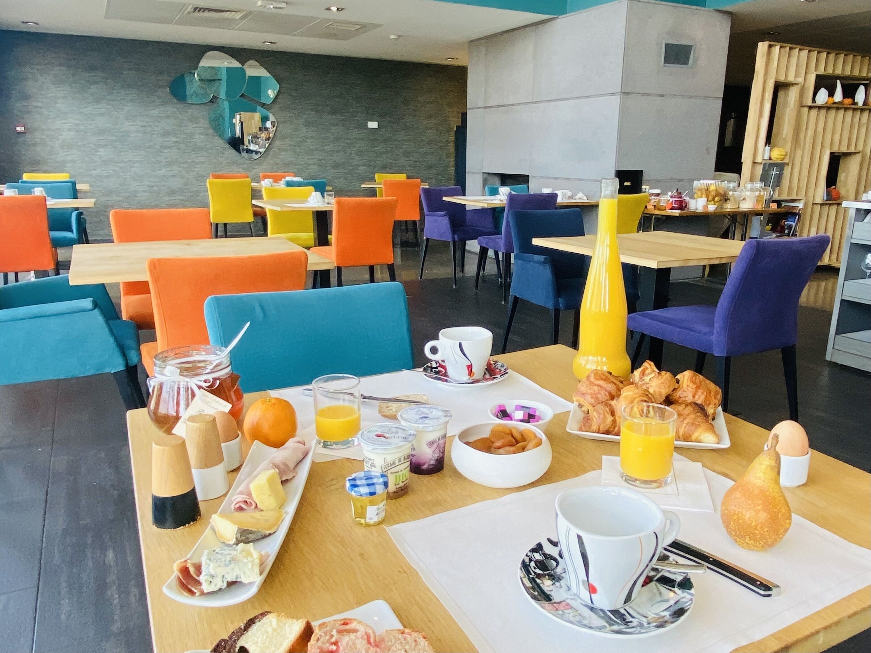 En frukostuppdukning med ett varierat utbud av matvaror, inklusive bakverk, frukt och drycker, som är upplagt på ett bord.