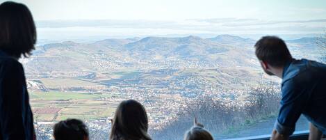 Una familia de cuatro personas contemplando una vista panorámica desde un lugar elevado, probablemente en una zona montañosa.